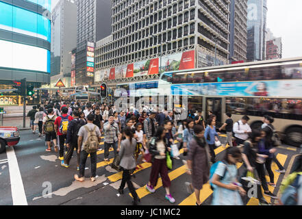 HONG KONG - APRIL 26, 2017: People, captured with blurred motion, cross Nathan road in the very crowded Mong Kok shopping district  in Kowloon. Stock Photo