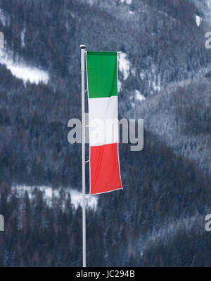 Italian flag waving by wind on pole at ski resort Stock Photo