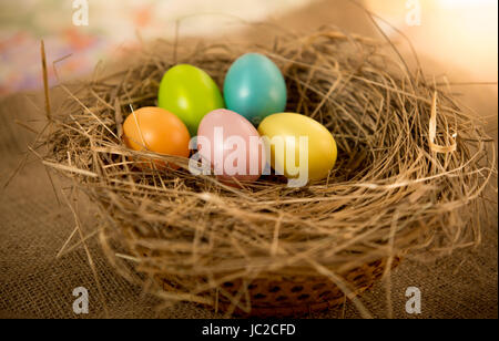 Five Easter eggs lying on table at nest Stock Photo