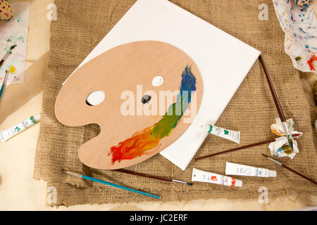Professional artist tools and paints lying on table at working studio Stock Photo