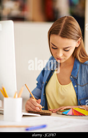 Portrait of pretty student of design faculty making sketch at lesson Stock Photo