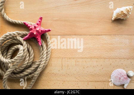 View from top on rope, seashells and red starfish lying on wooden boards Stock Photo