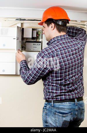Professional electrician installing components in electrical shield Stock Photo