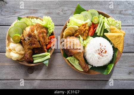 Famous traditional Indonesian food. Delicious nasi ayam penyet with sambal belacan. Fried chicken rice. Stock Photo