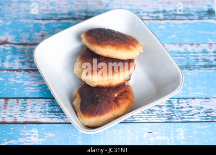 Fried pancakes. Fritters of cottage cheese. Cheese cakes on a blue wooden background. Stock Photo