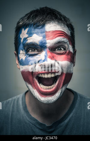 Portrait of exited man with US flag painted on face. Stock Photo