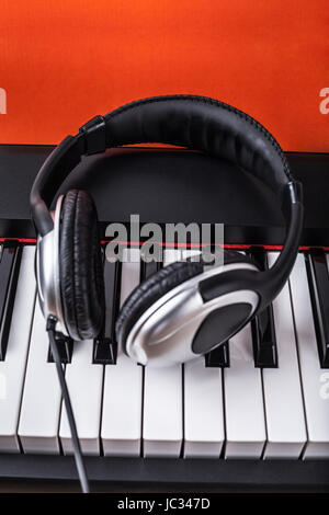 Detail of piano keyboard with headphones. Stock Photo