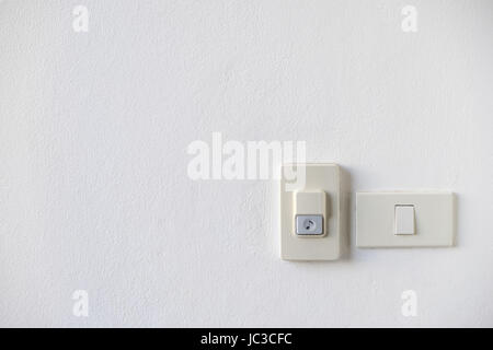 House Doorbell with light switch on white wall in front of the house Stock Photo