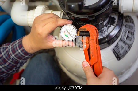 Closeup shot of plumber installing manometer on pipe Stock Photo
