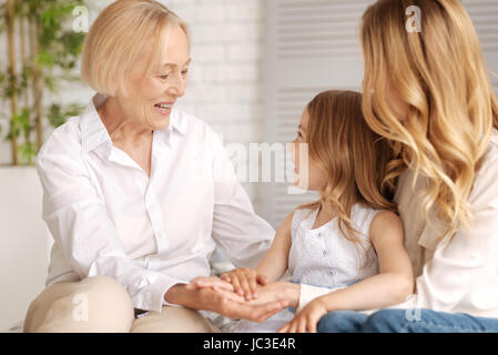 Three generations of women holding hands together Stock Photo