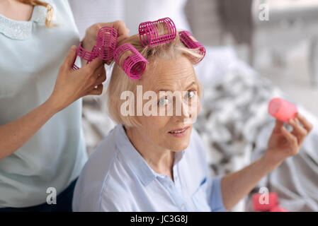 Female hands helping to fix hair rollers Stock Photo