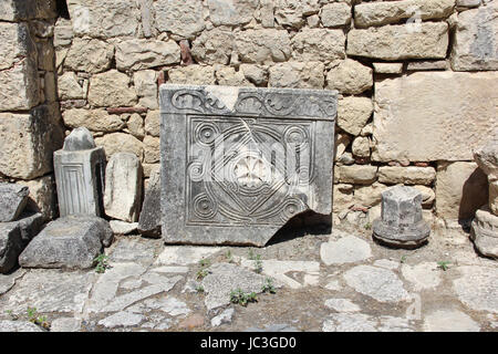 Carved bas-relief in Saint Nicolas church, Demre, Turkey, pattern cross on the stone floor plate. Wall with stone blocks Stock Photo