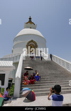The World Peace Pagoda in Pokhara Nepal sits on hill overlooking the Annapurna Mountain range which reflects off Phewa Lake Stock Photo