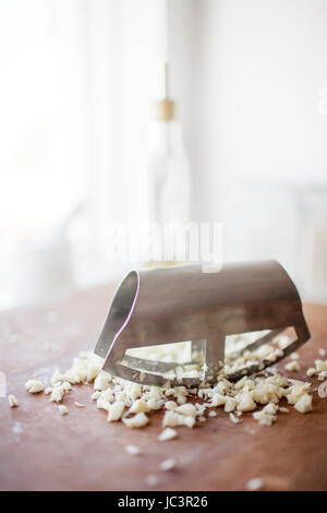 Garlic being chopped with a mincing knife Stock Photo