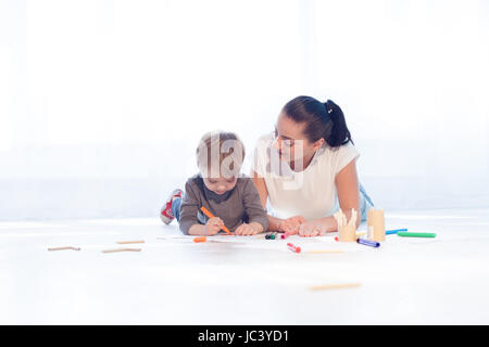 mother and young son painted pencils learn to draw Stock Photo