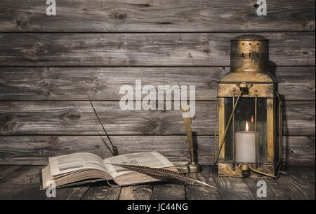 Old vintage background with book and feather and a antique lantern. Stock Photo