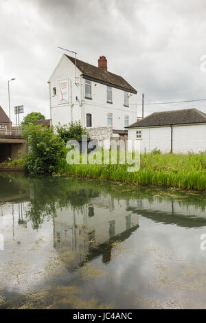 White commercial or industrial building reflected in the Birmingham to Wolverhampton canal at Coseley, Black country west midlands Stock Photo