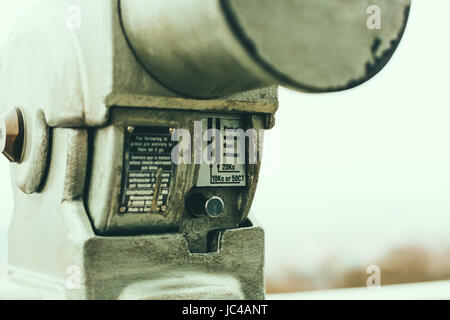 Close up on the coin slot on coin operated binoculars on the viewing platform, Prague, Czech Republic with the blurred city background. Stock Photo