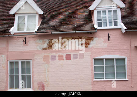 Pink Suffolk house wall prepared for painting with colour/color test  patches Stock Photo