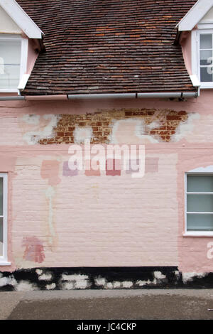 Pink Suffolk house wall prepared for painting with colour/color test  patches Stock Photo