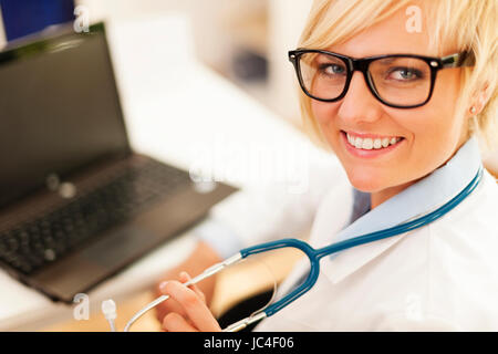 Portrait of beautiful blonde female doctor wearing glasses Stock Photo