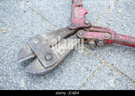 Tool for cutting reinforcement metal, bolt cutters are placed on marble background. Stock Photo