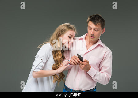 Business concept. The two young colleagues holding mobile phones on gray background Stock Photo