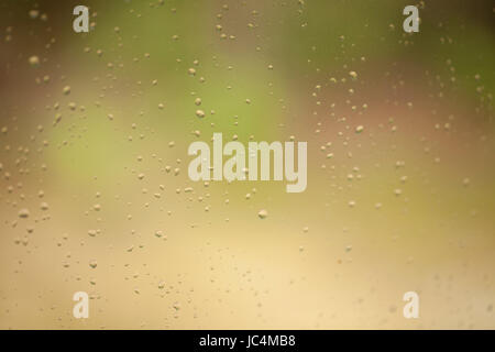 Rain drops on the window against a nice blurry background. Abstract, texture, background. Stock Photo