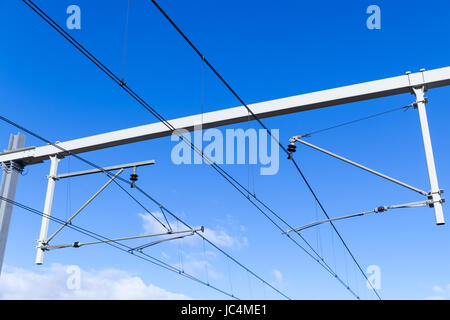 Overhead lines on Dutch railway under blue sky Stock Photo