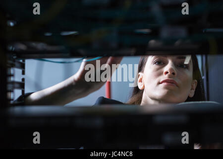 Serious beautiful technician doing her work Stock Photo