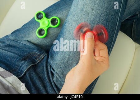 trendy fidget spinner - someone holding spinning fidget spinner in hand, close up view Stock Photo