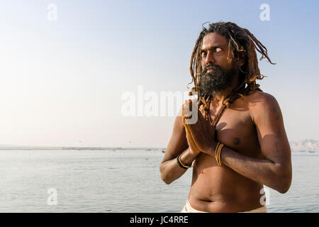 A Sadhu, holy man, is practising eye yoga asana on a platform at the holy river Ganges at Meer Ghat in the suburb Godowlia Stock Photo