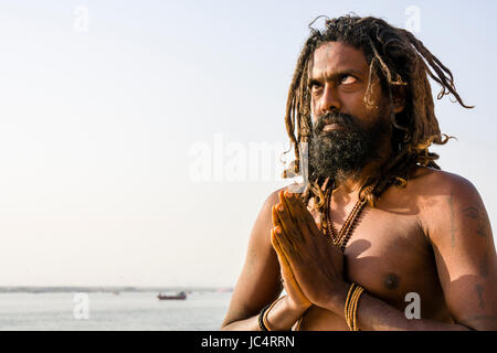 A Sadhu, holy man, is practising eye yoga asana on a platform at the holy river Ganges at Meer Ghat in the suburb Godowlia Stock Photo