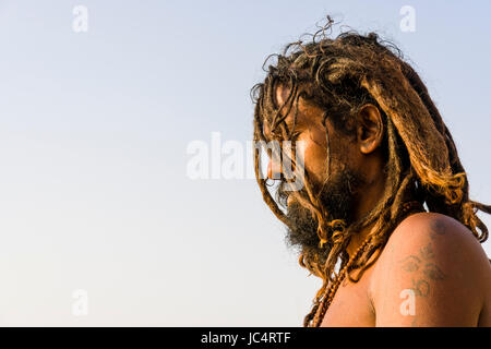 A Sadhu, holy man, is sitting and praying on a platform at the holy river Ganges at Meer Ghat in the suburb Godowlia Stock Photo