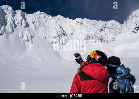 Professional Snowboarder Marie France Roy, and Robin Van Gyn, plan their lines they want to ride on a snowboarding trip in Haines Alaska. Stock Photo