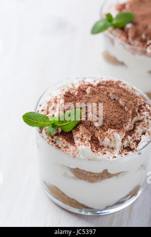 Classic Italian dessert tiramisu served in  glasses on white background Stock Photo