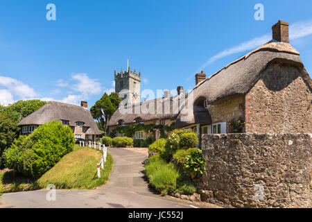 All Saints Church tower and thatched cottages, Godshill, Isle of Wight, UK Stock Photo