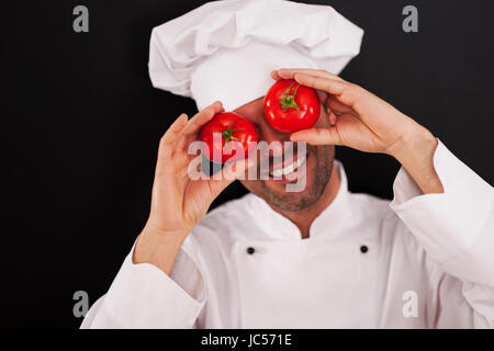 Happy chef covering his eyes of tomatoes Stock Photo