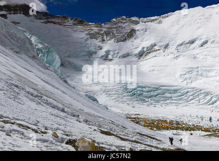 Climbers make their way up toward the West Ridge Headwall from Camp 2 / Advanced Basecamp on Mount Everest. Lhotse and Nuptse are visible behind. Stock Photo