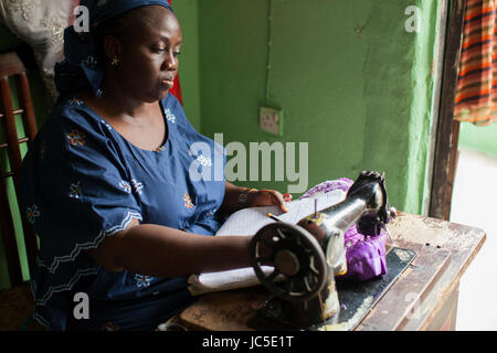 A female tailor using her sewing machine, Nigeria, Africa Stock Photo