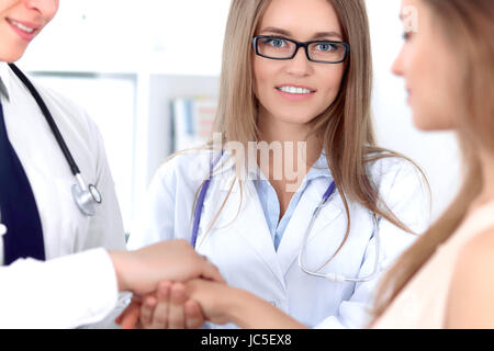 Friendly male doctor and female patient shaking hands.  Stock Photo