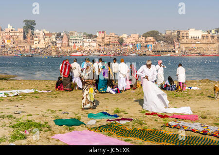 Pilgrims are gathering on the sand banks at the holy river Ganges, panorama of Dashashwamedh Ghat, Main Ghat, in the distance Stock Photo
