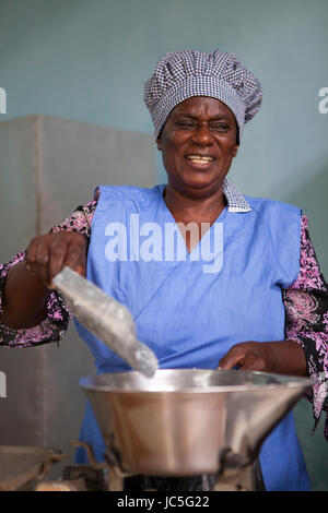 Beautiful woman weighing flour on kitchen scale for baking cake at home  stock photo