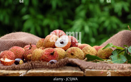 Close up of litchi fruit or lychee fruits, a tropical agriculture product at Luc Ngan, Bac Giang, Vietnam, basket of Vai thieu on green background Stock Photo