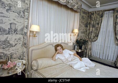 American actress Olivia de Havilland posing in the bedroom of her Paris apartment located 3 rue Bénouville in the 16th arrondissement.  c.1969 Photo Michael Holtz Stock Photo