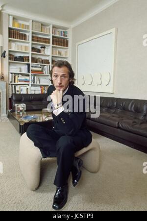 French fashion designer Marc Bohan posing in his Paris appartment, c.1972. Above the sofa, a painting by Montana. Photo Michael Holtz.  These photographic works are protected by legislation concerning literary and artistic property in all countries. Royalties are handled by ADAGP. To publish or diffuse these photographs, you must imperatively obtain the authorization of ADAGP or its correspondents abroad and to pay corresponding royalties. If you download this image in high definition, your postal address, telephone number and e-mail address will automatically be forwarded to ADAGP. ADAGP - 11 Stock Photo