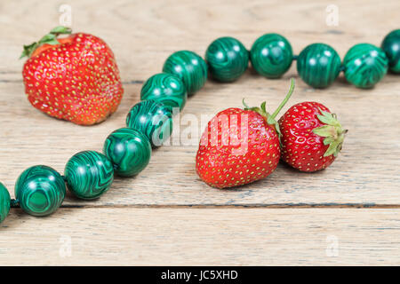 Strawberry next to necklace on the table Stock Photo
