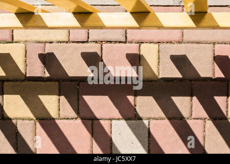 Paving stone with a shadow from fence Stock Photo