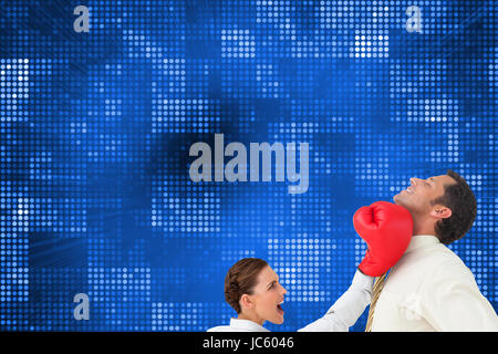 Composite image of businesswoman hitting a businessman with boxing gloves Stock Photo