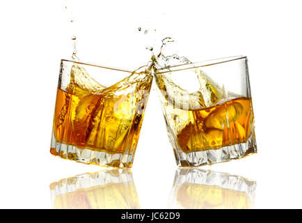 Two whiskey glasses clinking together, isolated on white. Stock Photo